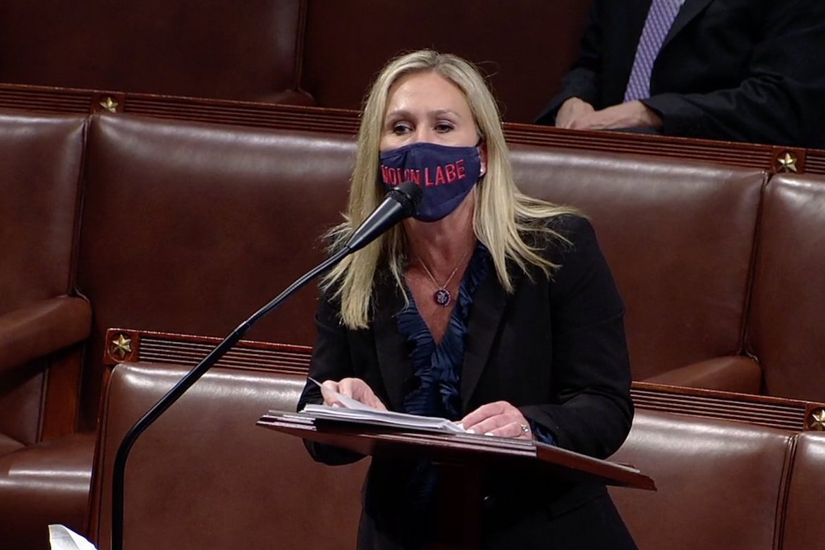 A still image from C-SPAN of representative Marjorie Taylor Greene wearing a facemask bearing the text "MOLON LABE."